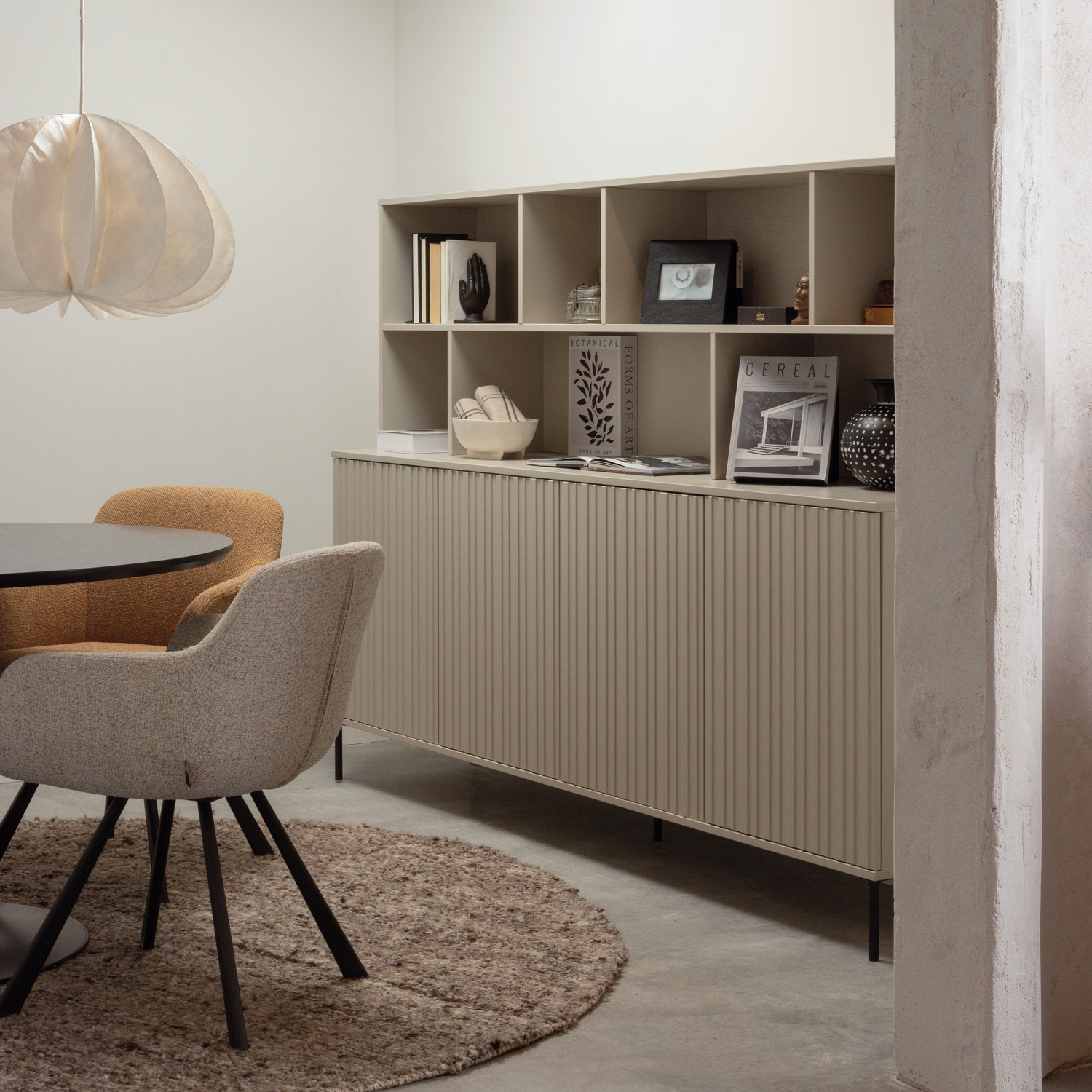 New Gravure wandkast in grenen dust naast een Juno eetkamerstoel, samen in een stijlvolle eetkamersetting met accessoires.