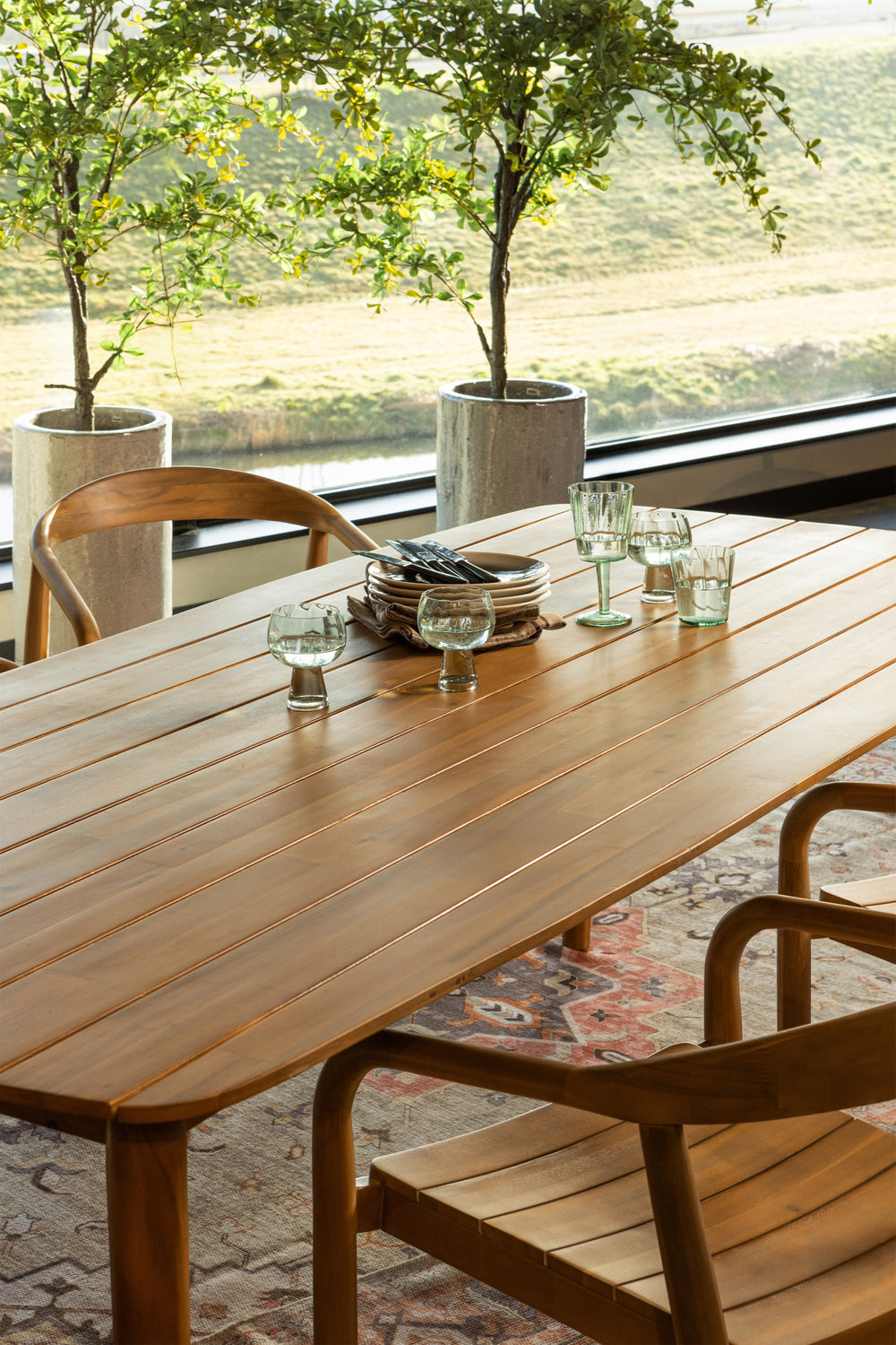 Tuinopstelling met WOOOD Kris tafel en Boru stoelen, klaar voor gebruik met borden en glazen op tafel
