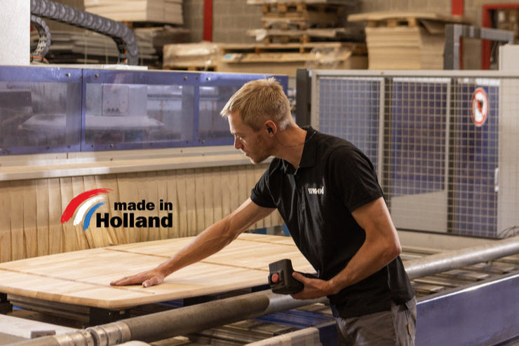 Foto van een medewerker in de fabriek van WOOOD waar alle houten producten worden gemaakt. 